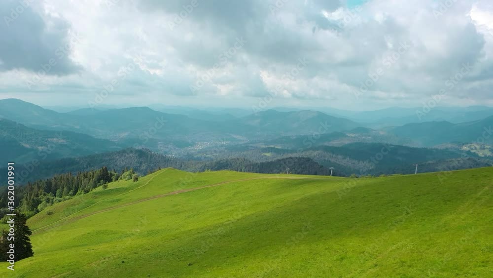 Aerial Drone View mountains covered with green grass and green trees. View of the mountain tops covered with dense forests. Fabulous view of the Carpathian mountains in Ukraine. Aerial Drone View mountains covered with green grass and green trees. View of the mountain tops covered with dense forests. Fabulous view of the Carpathian mountains in Ukraine.