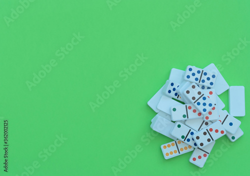 Playing dominoes on green table. Selective focus. Board games concept. Stay at home and play games. Flat lay style with copy space.