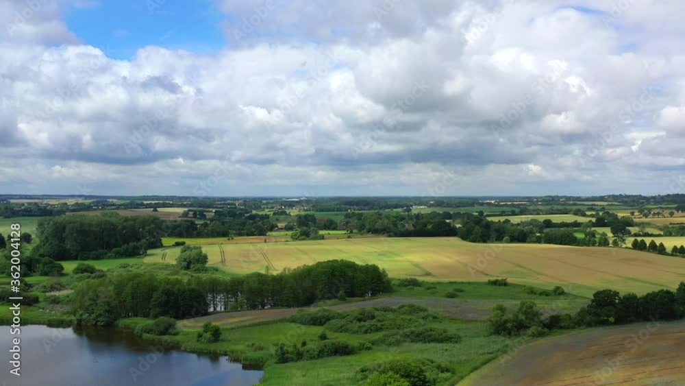 a drone-image of a North German landscape with thick clouds in the sky in fast motion a drone-image of a North German landscape with thick clouds in the sky in fast motion