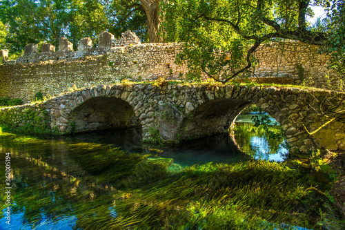 View of the Roman bridge of Ninfa, an ancient medieval town located in the province of Latina, Italy. Now it is part of the complex of Ninfa gardens.