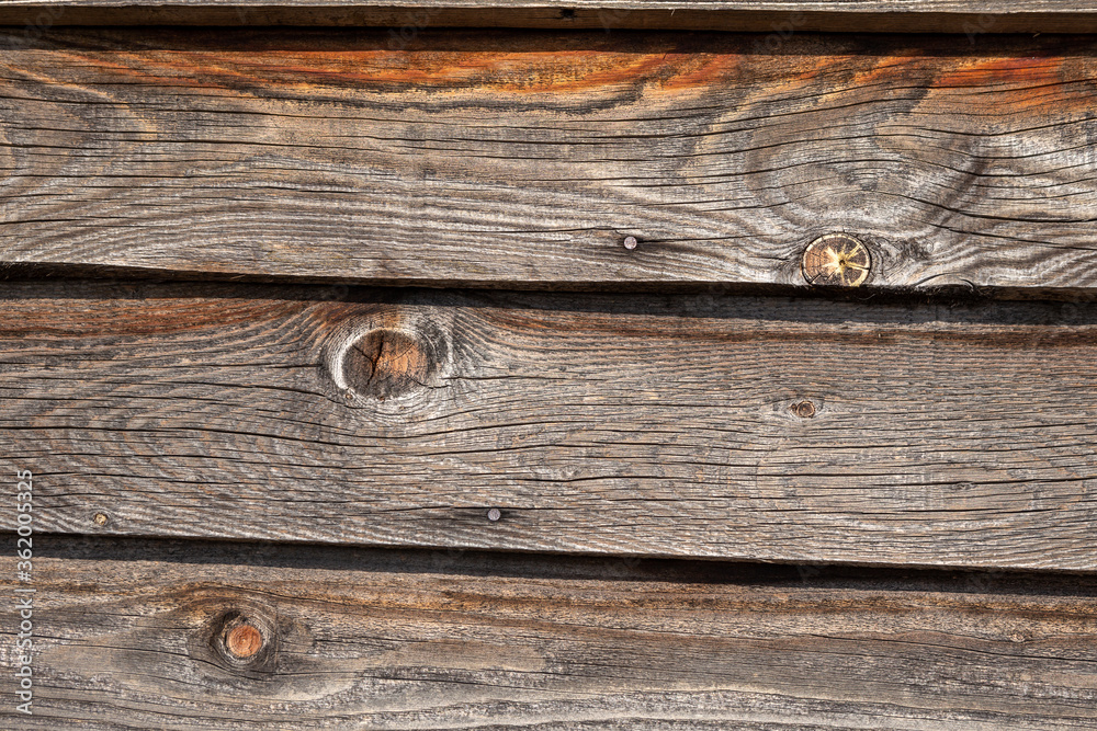 Wallpaper in the form of a wooden wall on the house. The wall is made next to the piles of pine wood. Copy Space. Wooden. Sun. Wallpaper in the form of a wooden wall on the house. The wall is made next to the piles of pine wood. Copy Space. Wooden. Sun.