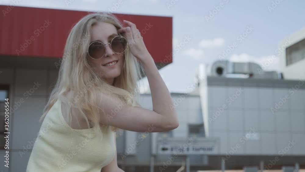 Portrait of a beautiful modern girl with round glasses in the city. Seasonal style, summer beauty, fashion. Portrait of a beautiful modern girl with round glasses in the city. Seasonal style, summer beauty, fashion.