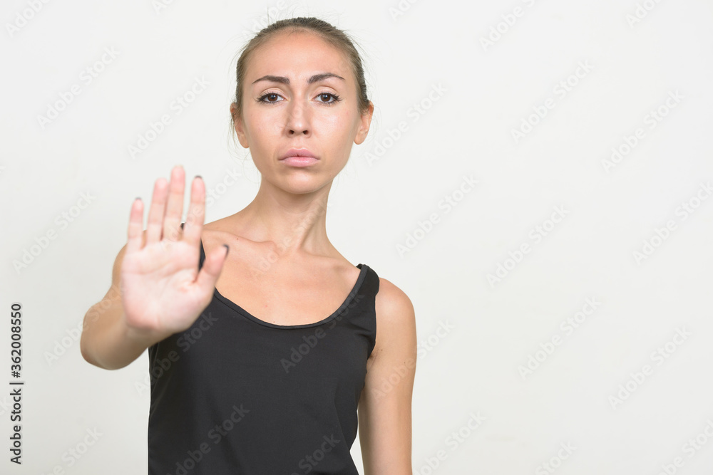 Young woman with brown hair showing stop gesture Young woman with brown hair showing stop gesture
