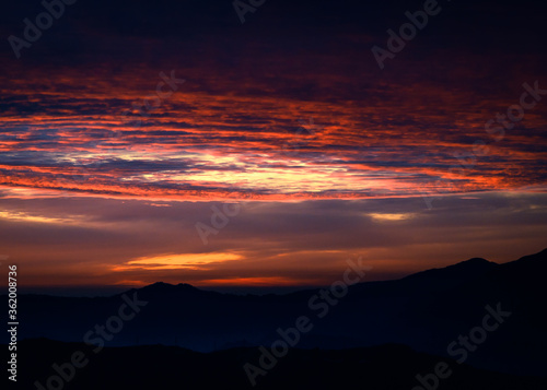 Colorful  vibrant  burning sunset skies  dramatic clouds  Himalayan mountains on Trek to Dalhousie