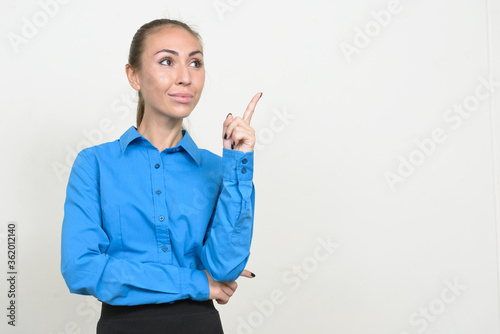 Portrait of young businesswoman thinking and pointing up