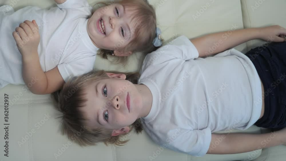 happy family kids brother and sister play on the couch laugh tickle each other. children little boy and girl play indoors laughing and fun happy lifestyle childhood happy family kids brother and sister play on the couch laugh tickle each other. children little boy and girl play indoors laughing and fun happy lifestyle childhood