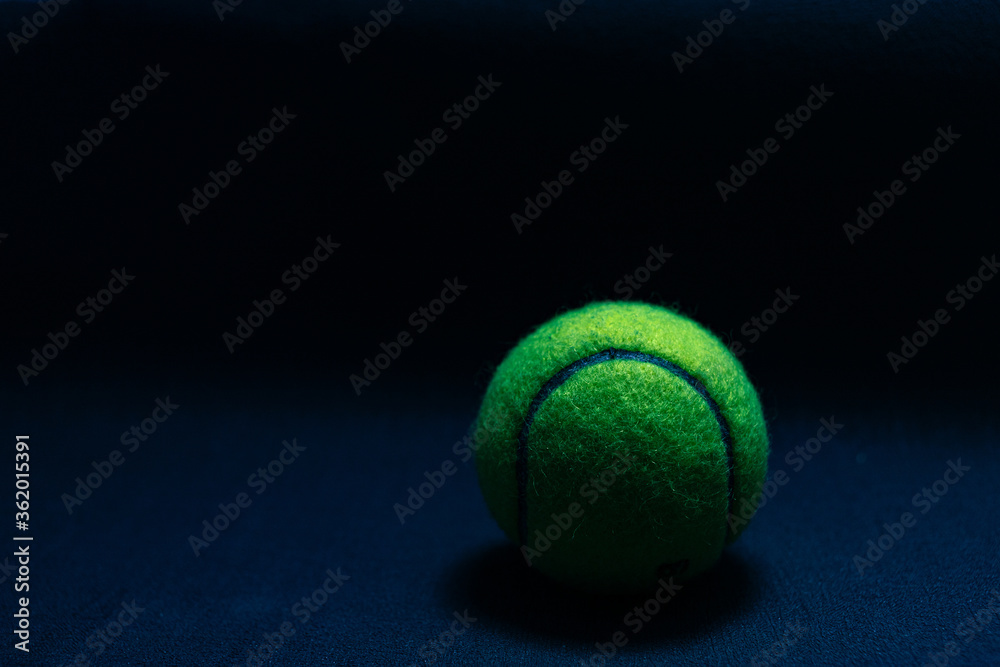 tennis ball isolated on dark background in hard light
