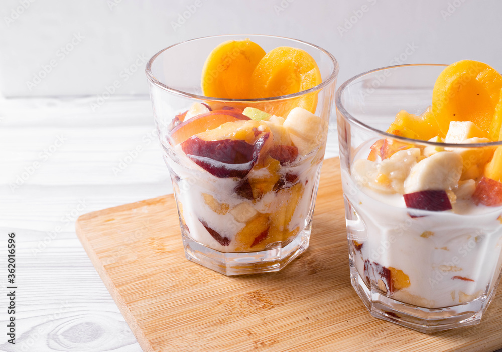 delicious melted natural ice cream or cold youghurt desert with tropical fresh fruits on the light rustic background delicious melted natural ice cream or cold youghurt desert with tropical fresh fruits on the light rustic background