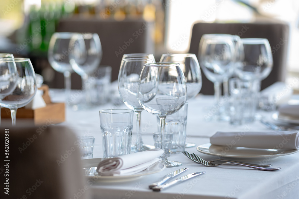 Empty glasses in restaurant background. Table set for an event party or wedding reception. Empty glasses in restaurant background. Table set for an event party or wedding reception.