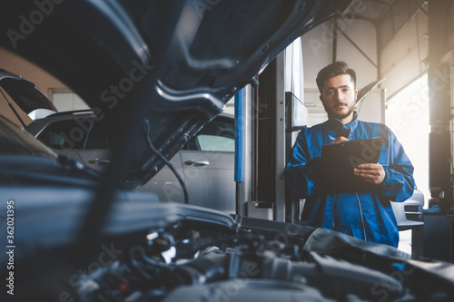 Auto mechanic fills in car repair documentation. Car service concept