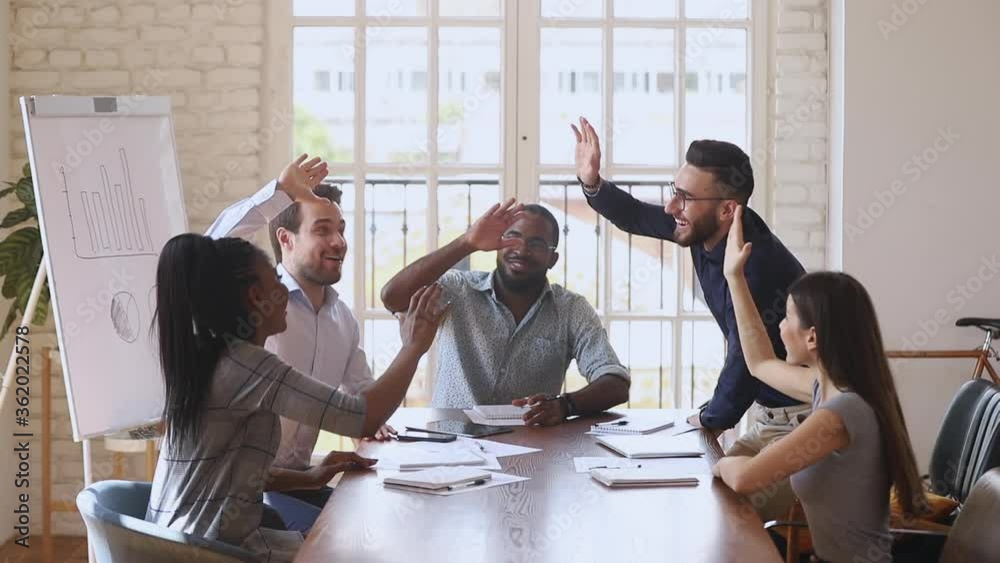 Happy overjoyed business team give high five celebrate successful contract, corporate victory professional triumph good teamwork result profit in financial report sit at office table at group meeting
