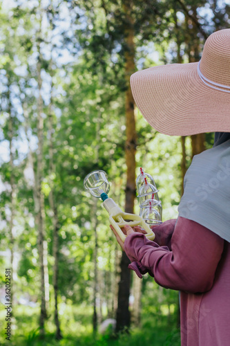 The girl holds in her hands jars for hijama and a pump. Bloodletting. Muslim hijam. The doctor who does the bloodletting. Flowers Sunnah treatment. Muslim girl in a pink dress. Hijab.