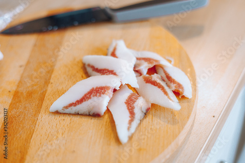 Pancetta e guanciale tagliati a strisce per aperitivo o snack a base di taglieri di salumi e formaggi.