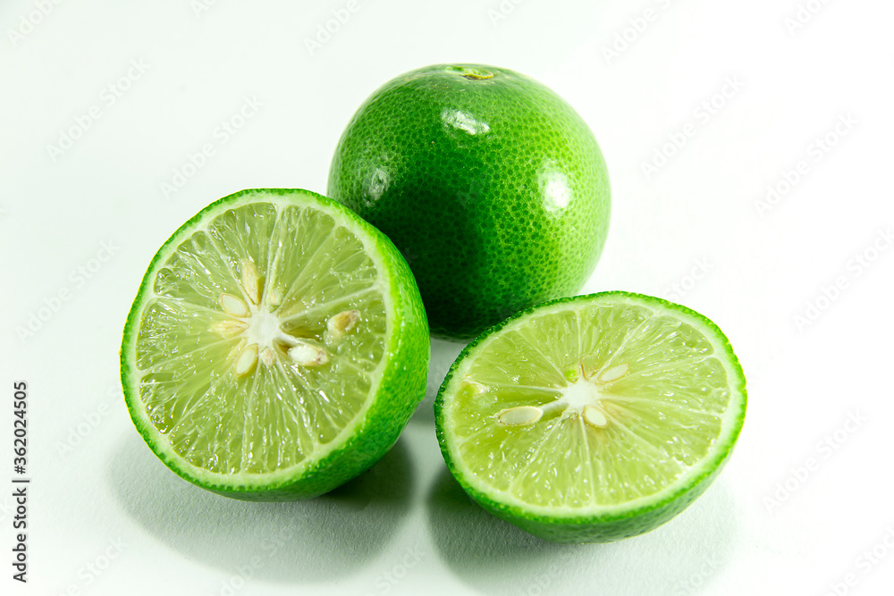 Thai lemons are placed in front of the fruit cluster and separated from a white background.