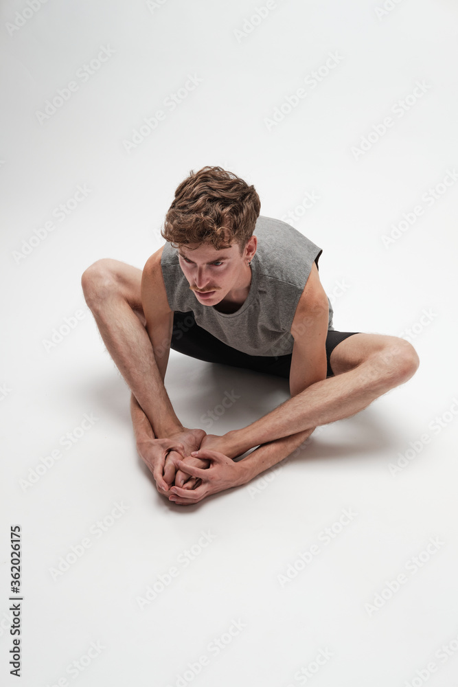 Obraz premium Young boy doing streching on white background