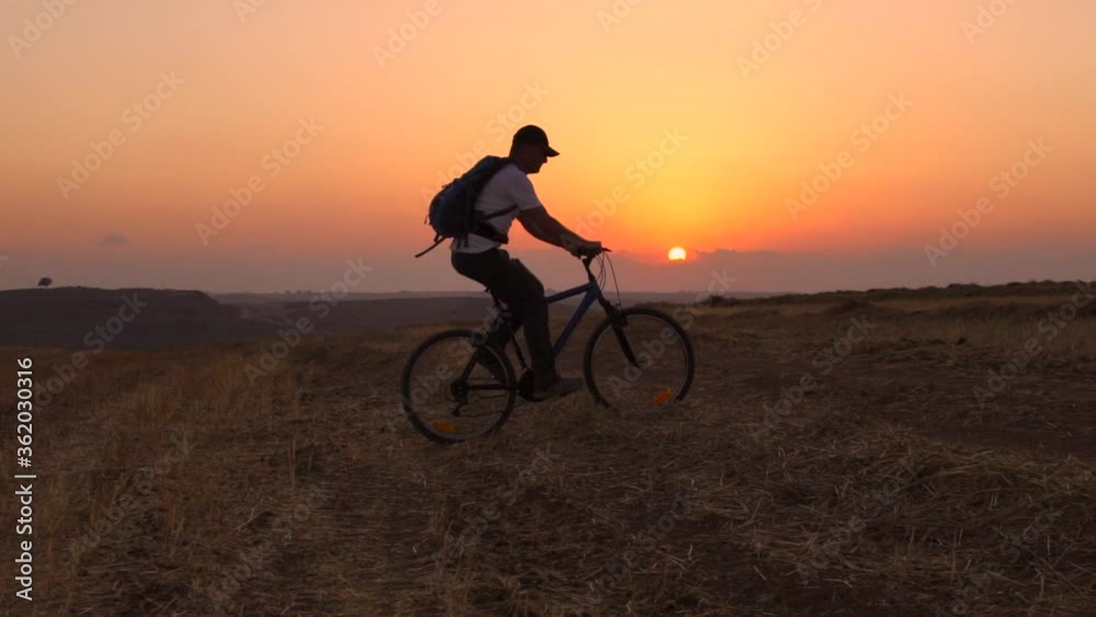 Man Riding Bicycle During Sunset, Outdoors Activity, Sport ,Summer Field - slow motion Man Riding Bicycle During Sunset, Outdoors Activity, Sport ,Summer Field - slow motion