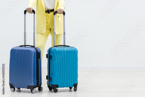 Cropped shot of young female traveler with two suitcases ready to explore new destination.