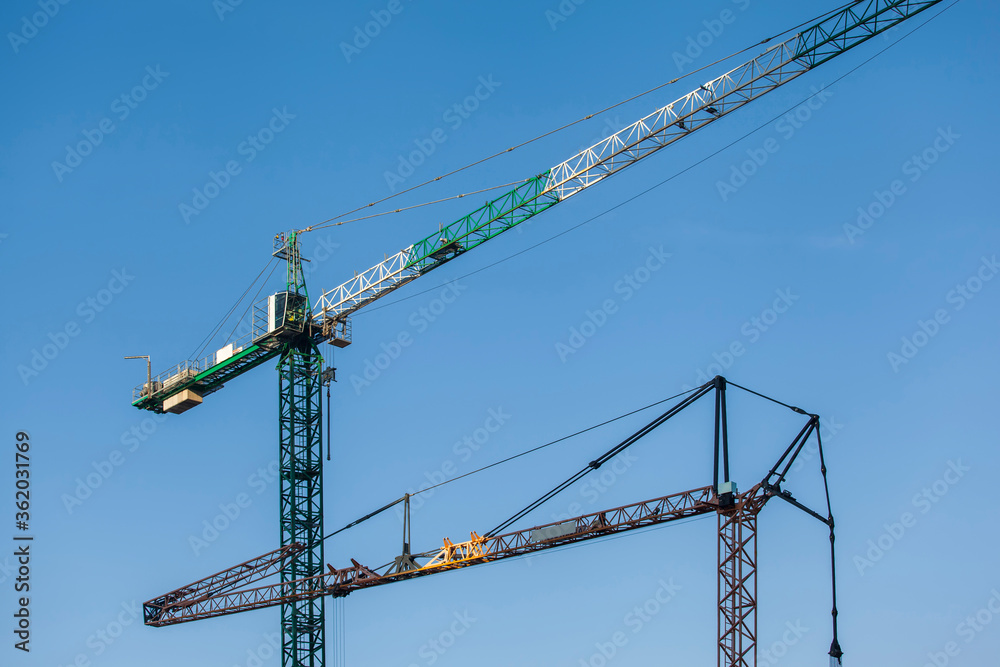 tower cranes on a background of blue sky	
