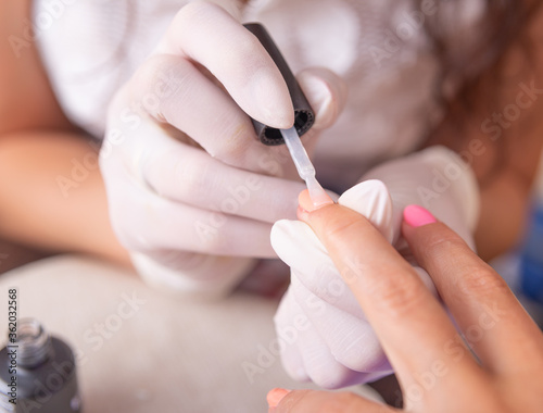 Nails painting on manicure. Woman in beauty spa salon doing manicure 