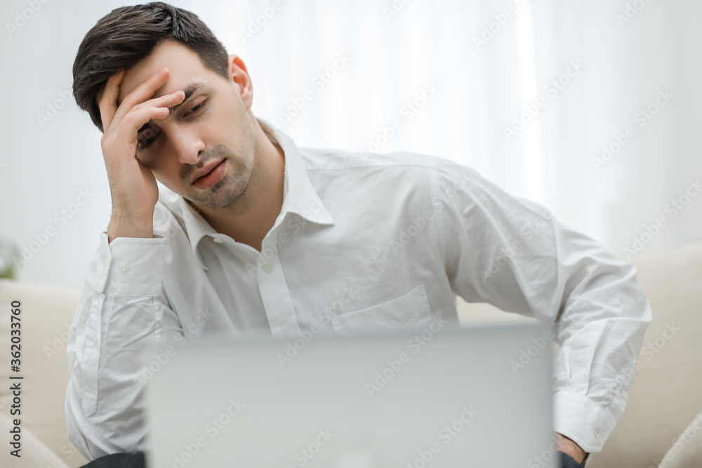 Frustrated with problems young business man working on laptop computer at home. Frustrated with problems young business man working on laptop computer at home.