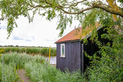  Wooden holiday cottage on the bank of the River Thurne in the Norfolk Broads National Park