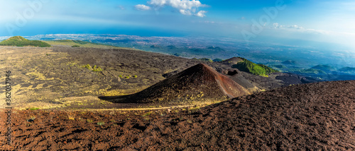Panorama view of volcanic craters from the summit of Mount Etna, Sicily looking towards the coast in summer