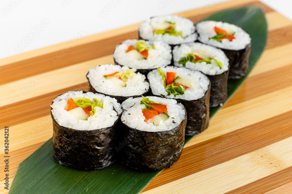 Maki Sushi Rolls set on wooden bamboo board. Japanese traditional Cuisine. White background. Maki Sushi Rolls set on wooden bamboo board. Japanese traditional Cuisine. White background.