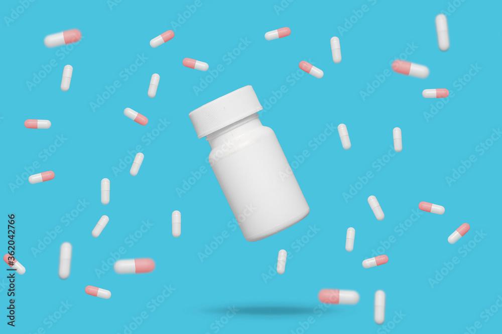 Mixture of red and white medicine pills capsules tablets floating around a floating pill bottle on a blue background Mixture of red and white medicine pills capsules tablets floating around a floating pill bottle on a blue background