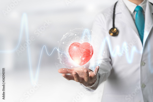 Medicine doctor holding red heart shape in hand with Technology Innovation and medicine concept.