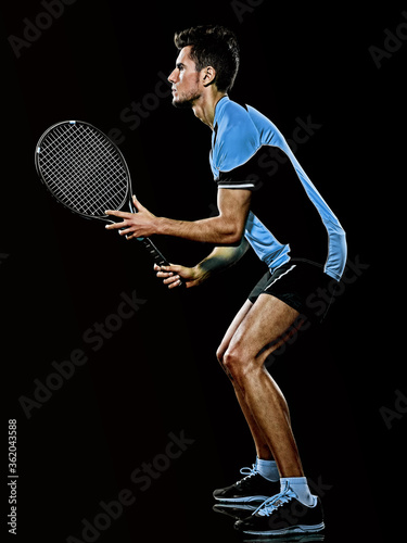 one caucasian young player tennis man in studio isolated on black background © snaptitude