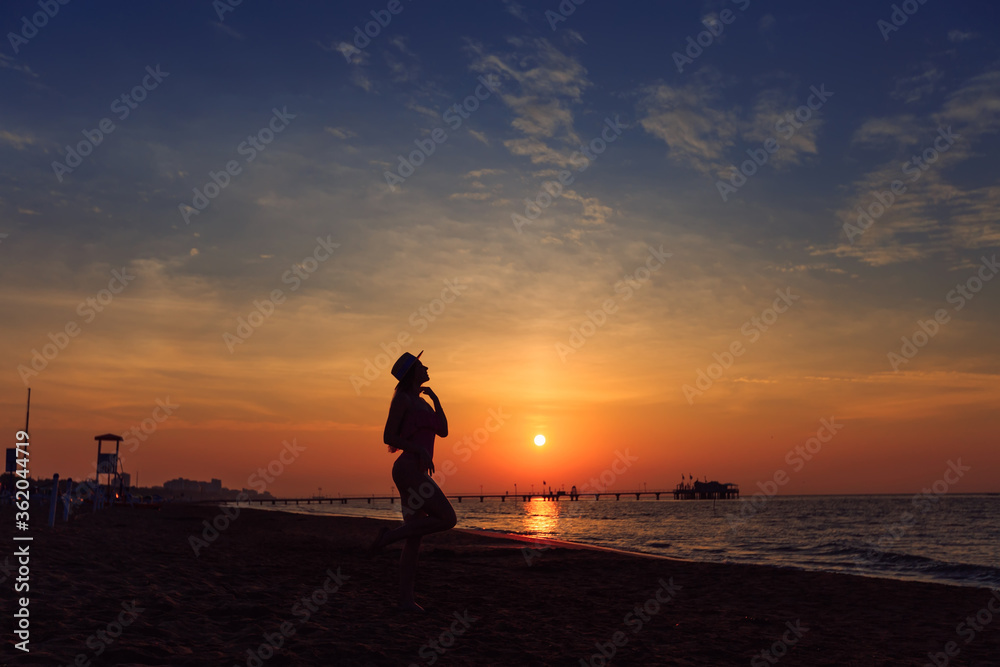 girl silhouette with long hair in boater on the background of th
