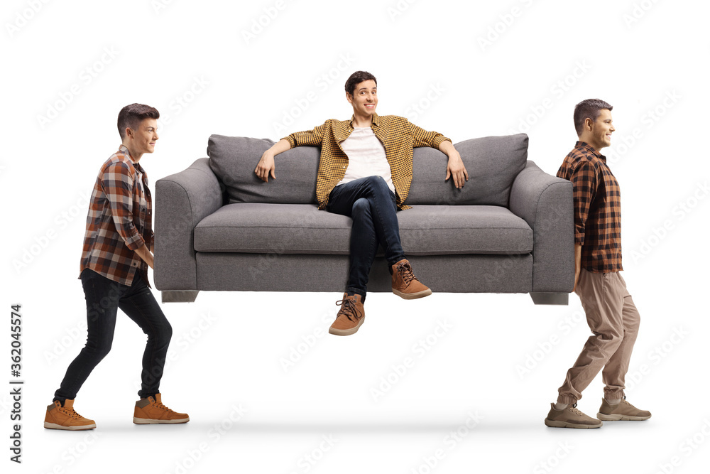 Young men carrying a sofa with a man sitting on it Young men carrying a sofa with a man sitting on it