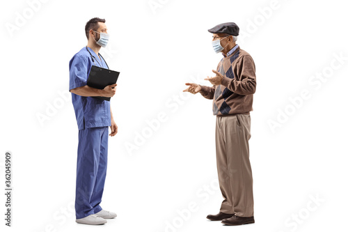 Medical worker with a mask talking to an elderly man