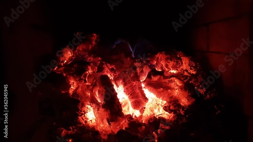 Bright red coals in a brick oven. On the background of brickwork, with a red tint from the fire. Heat is created inside.