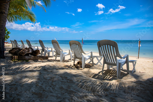 Empty chair on white sand beach. Hotel facility with no tourist. Tropical island holiday destination.