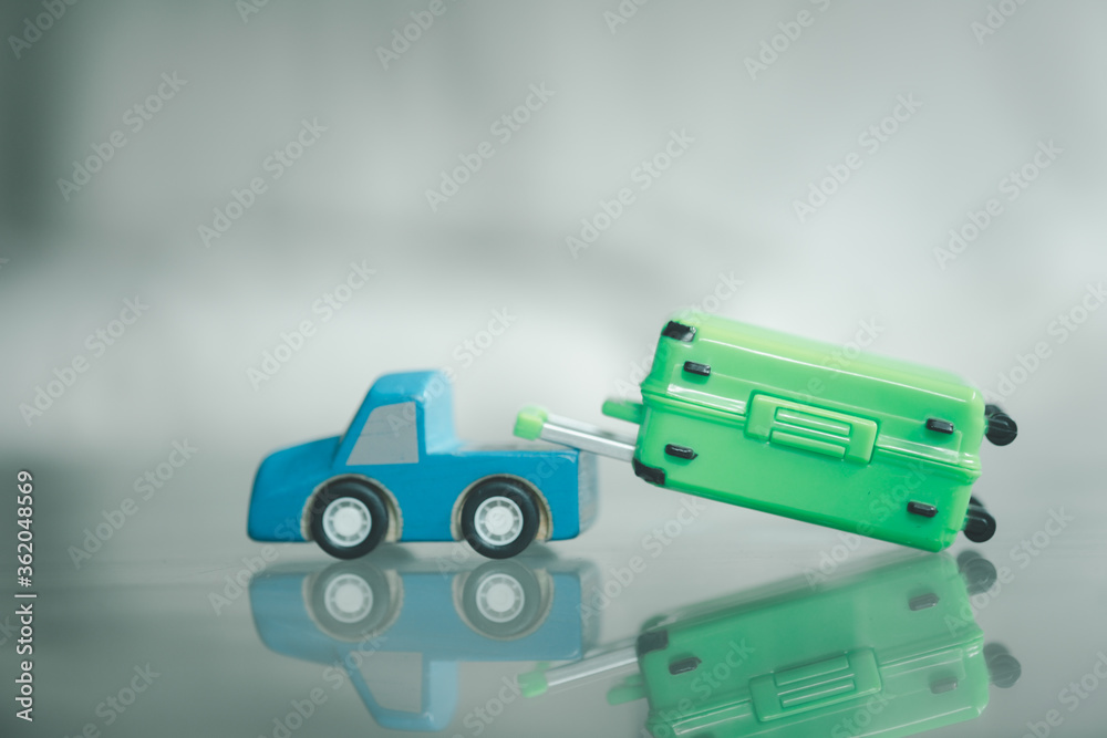 Miniature wood blue toy car with suitcase. Concept of travel in new normal