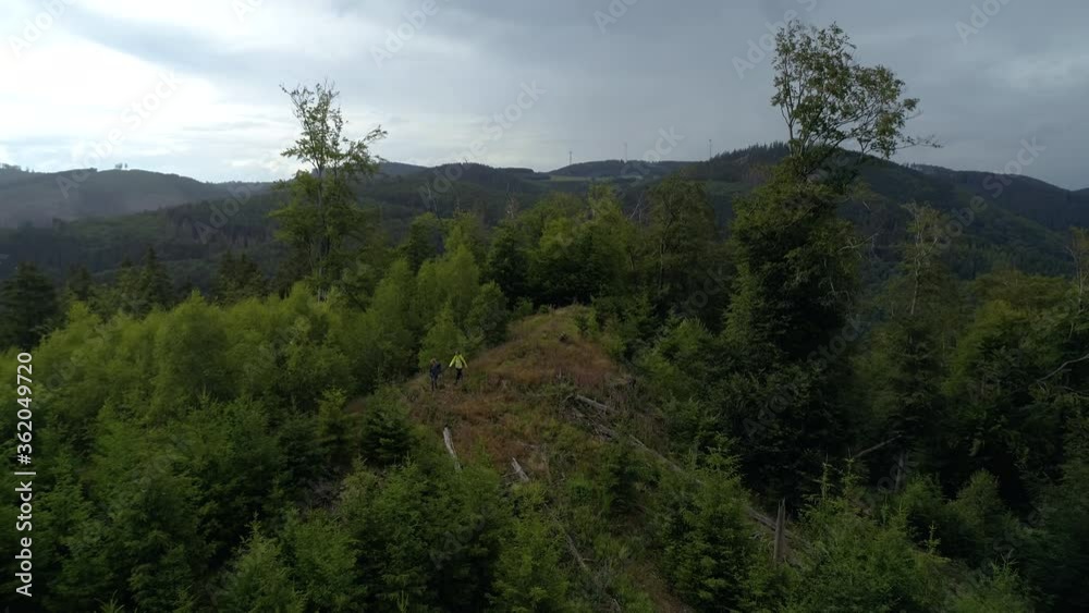 Drone Shot of Two People Hiking through the Woods. Mystic Forest and Mountains in Germany. Aerial Shot of a Foggy Landscape. Drone Shot of Two People Hiking through the Woods. Mystic Forest and Mountains in Germany. Aerial Shot of a Foggy Landscape.