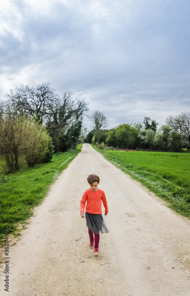 Fototapeta premium petite fille sur un chemin de campagne