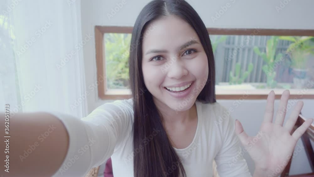 A beautiful young woman is taking video call with her friends in coffee shop , happy and smiling ,communication technology concept A beautiful young woman is taking video call with her friends in coffee shop , happy and smiling ,communication technology concept