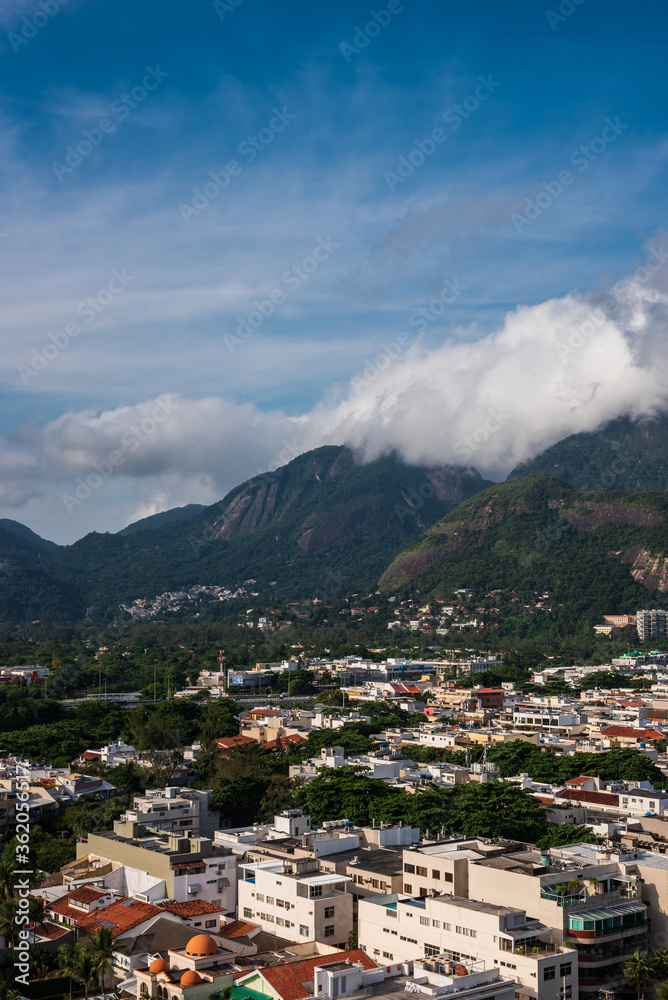 Landscape view of the mountais and part of Rio de Janeiro city integrated with a cloudy and sunny blue sky