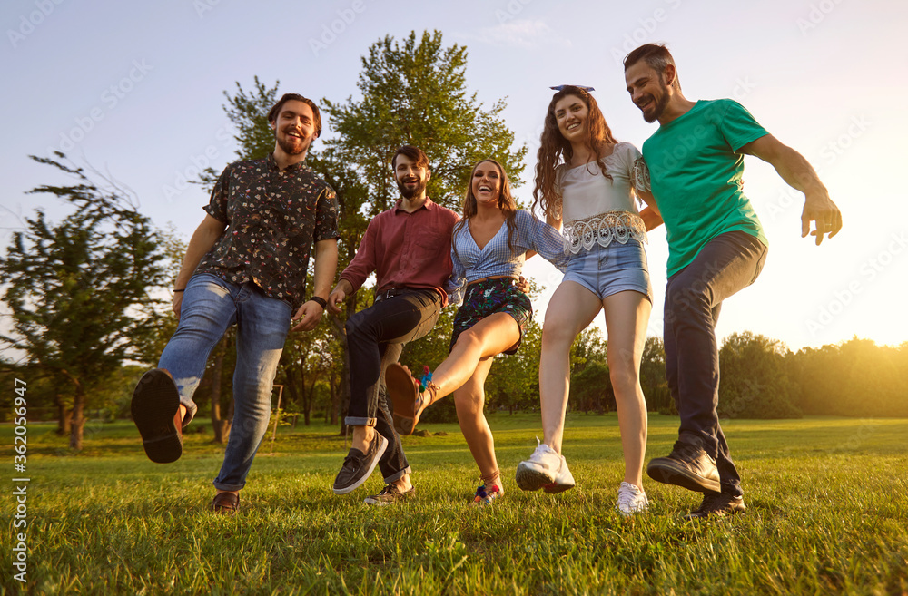 Obraz premium Happy friends dancing and laughing outdoor. Joyful young people having fun and being silly on weekend in countryside