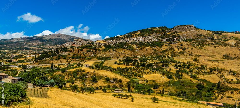 A panorama view of the hilltop village of Petralia Sottana against the backdrop of the Madonie Mountains, Sicily during summer