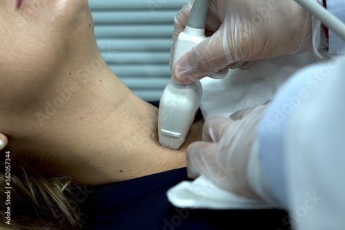endocrine doctor performing a thyroid ultrasound on a patient close-up. Physical exam of a patient, endocrine system problems