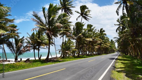 Road by the sea in the Dominican Republic. Highway between the sea and coconut trees