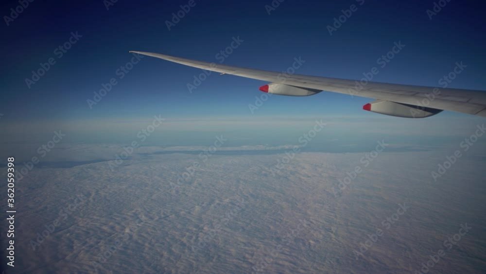 4K, Wonderful clouds with light sun from above, as seen through airplane window. View of plane wing in flight trip, traveling by air. Vacation journey concept-Dan 4K, Wonderful clouds with light sun from above, as seen through airplane window. View of plane wing in flight trip, traveling by air. Vacation journey concept-Dan