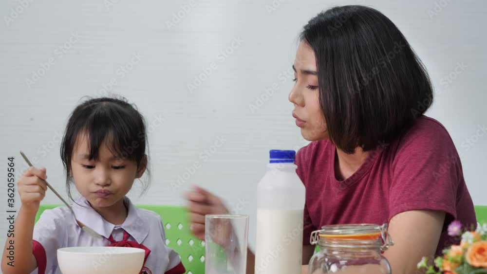 mom daughter spend time eating breakfast together before going to elementary school. mom daughter spend time eating breakfast together before going to elementary school.