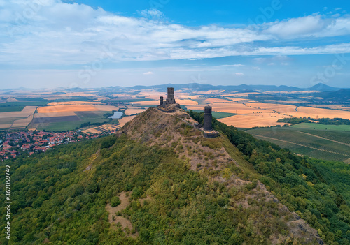 Aerial view of two stone towers,  ruins of medieval castle Hazmburk, Hasenburg built on top of the mountain peak, surrounded by agriculture czech landscape. Tourist point, castles of western Bohemia photo