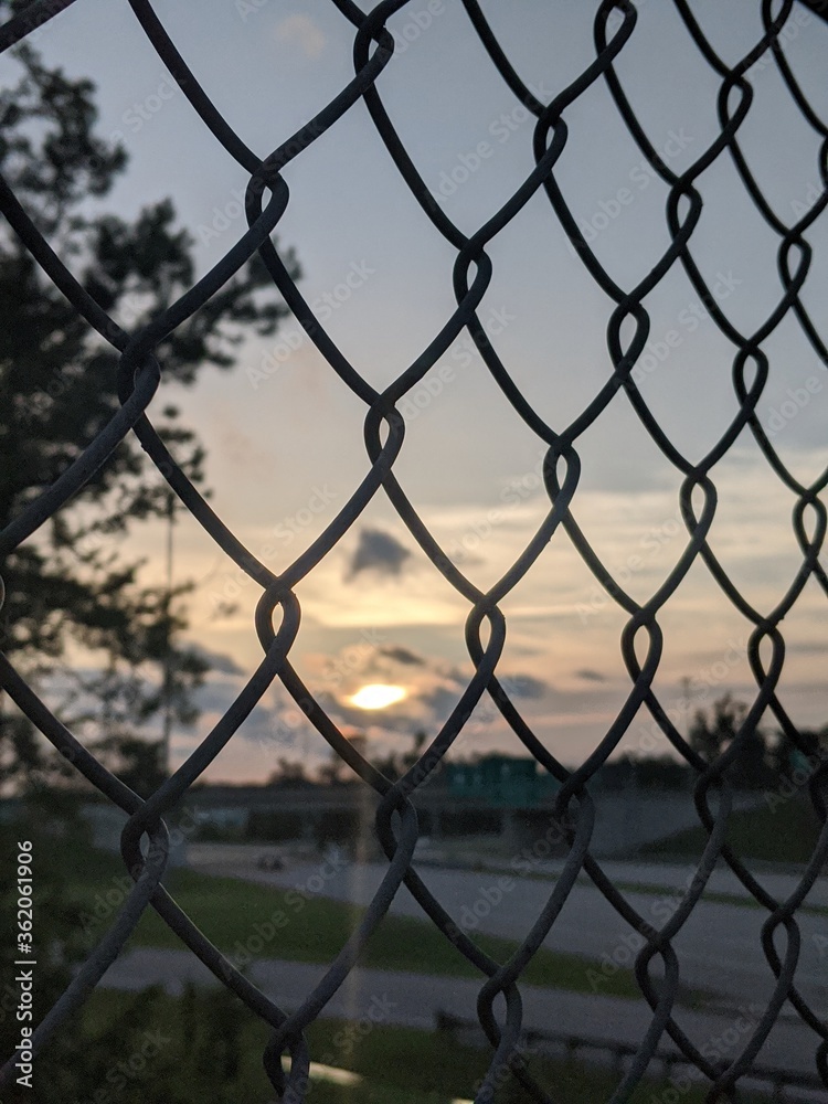 chain link fence with sunset. chain link fence with sunset.