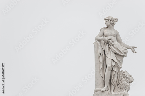 Old roof statue of a Renaissance Era woman philosopher and poet with a lion in Potsdam at white creamy background and copy space for text, Germany