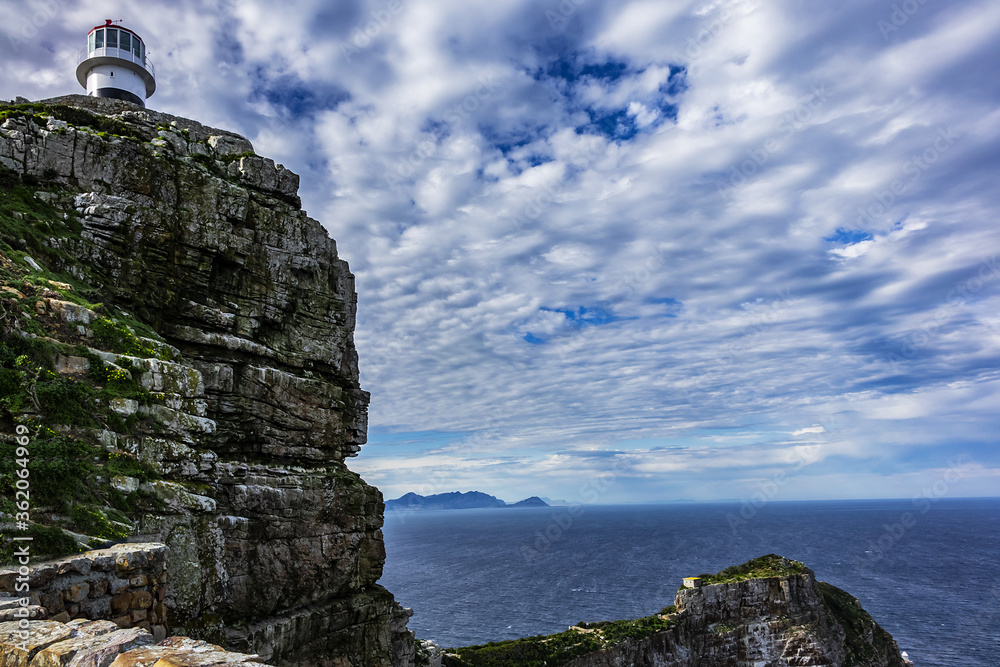 Fototapeta premium Old lighthouse (1857) sits on top of cliffs of Cape Point in Cape of Good Hope Nature Reserve on southern tip of Cape Peninsula in South Africa. The Atlantic and Indian oceans converge at Cape Point.